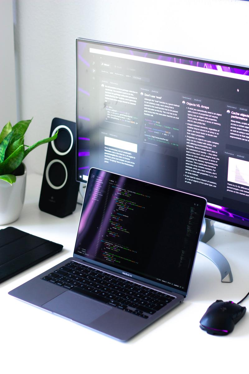web designing on Mac book with code and second monitor showing web design